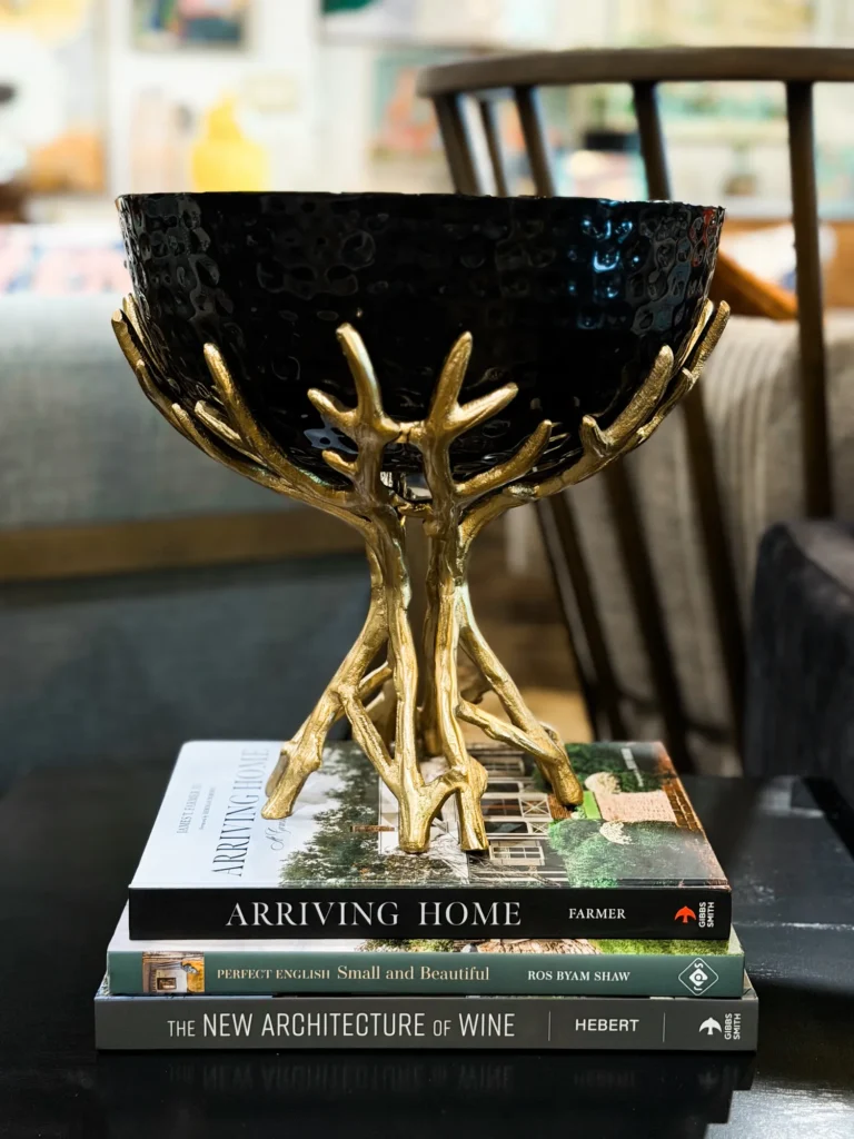 Black bowl on a gold stand styled on coffee table books