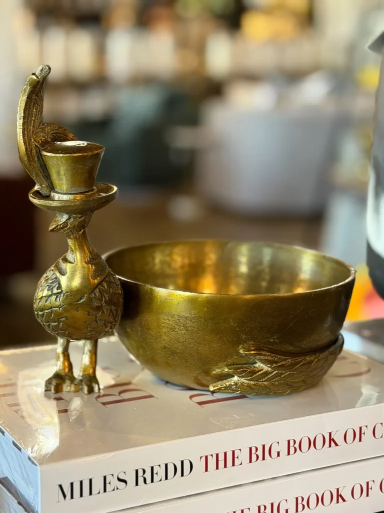 Brass bird candleholder and bowl on a book