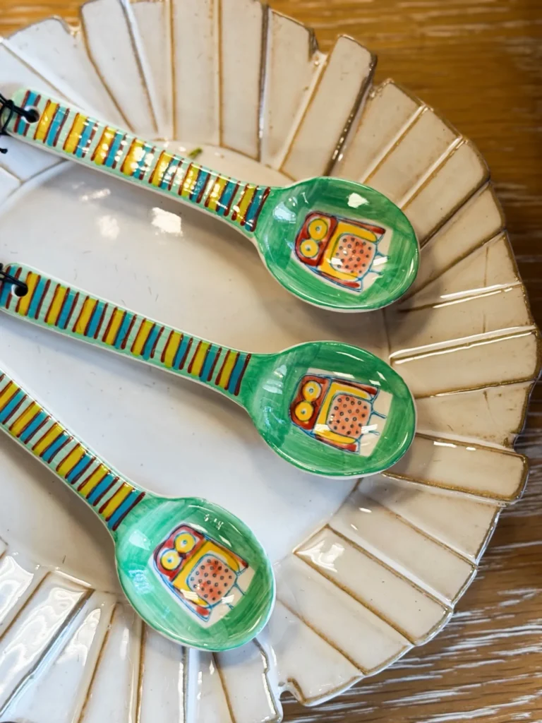 Colorful enamel spoons on a sunburst mirror
