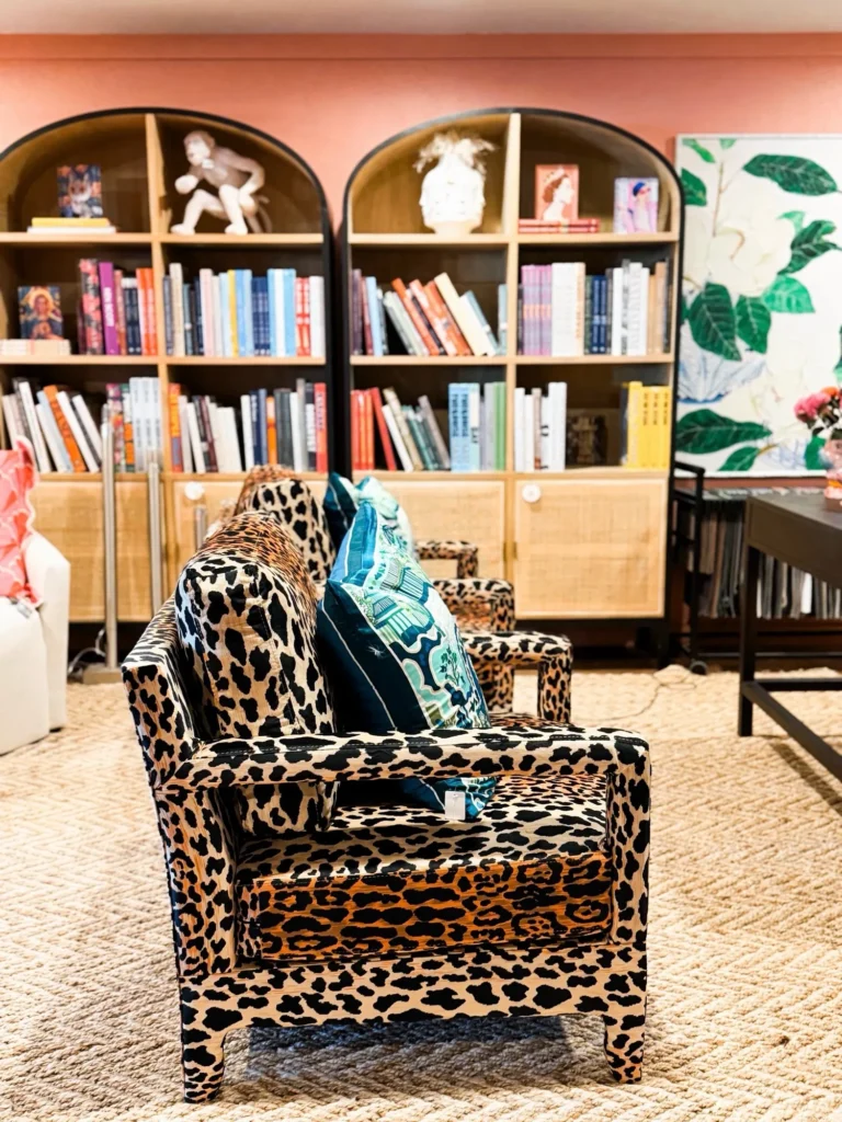 Leopard print armchair in front of arched bookshelves at Live Boho