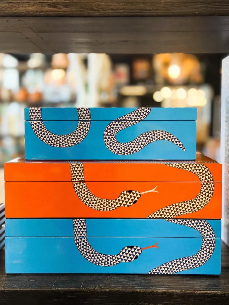 Stacked orange and blue decorative boxes with a snake pattern
