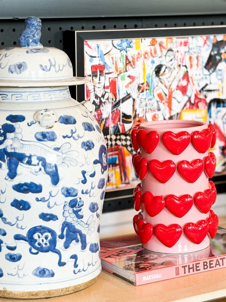 Red heart vase beside a blue and white ginger jar
