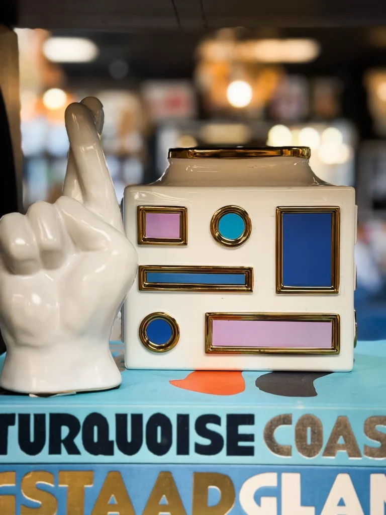 Retro camera-shaped decor and a hand sculpture on colorful books