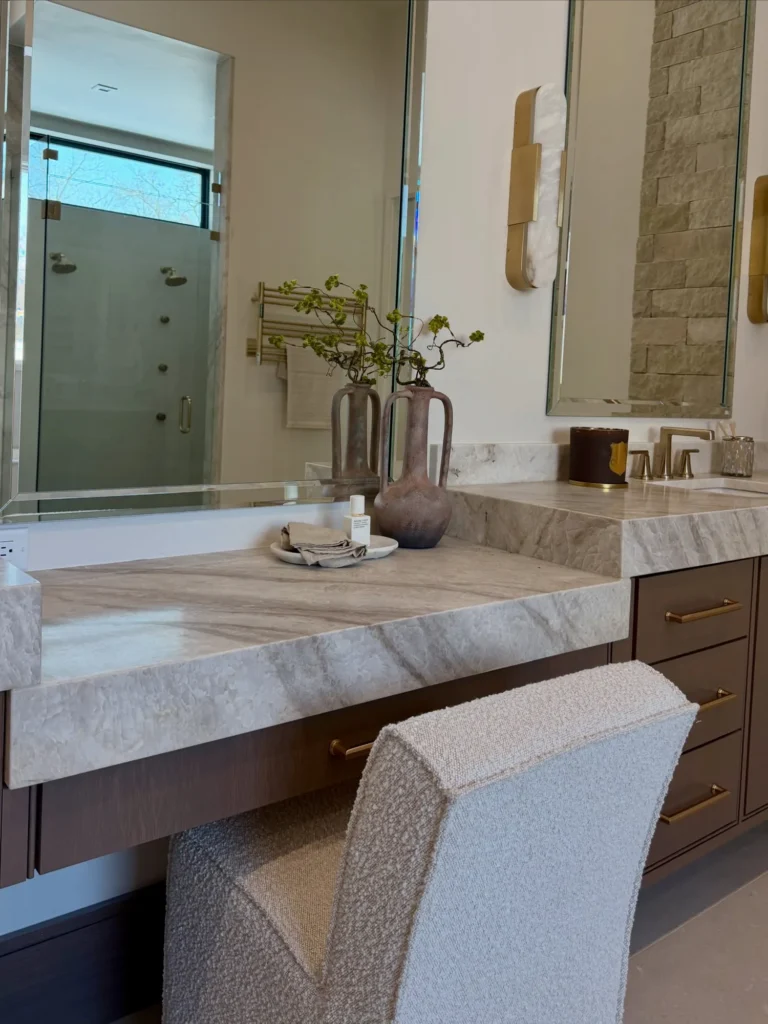 Staged bathroom vanity with a marble counter and upholstered chair – home staging Oklahoma City by Live Boho