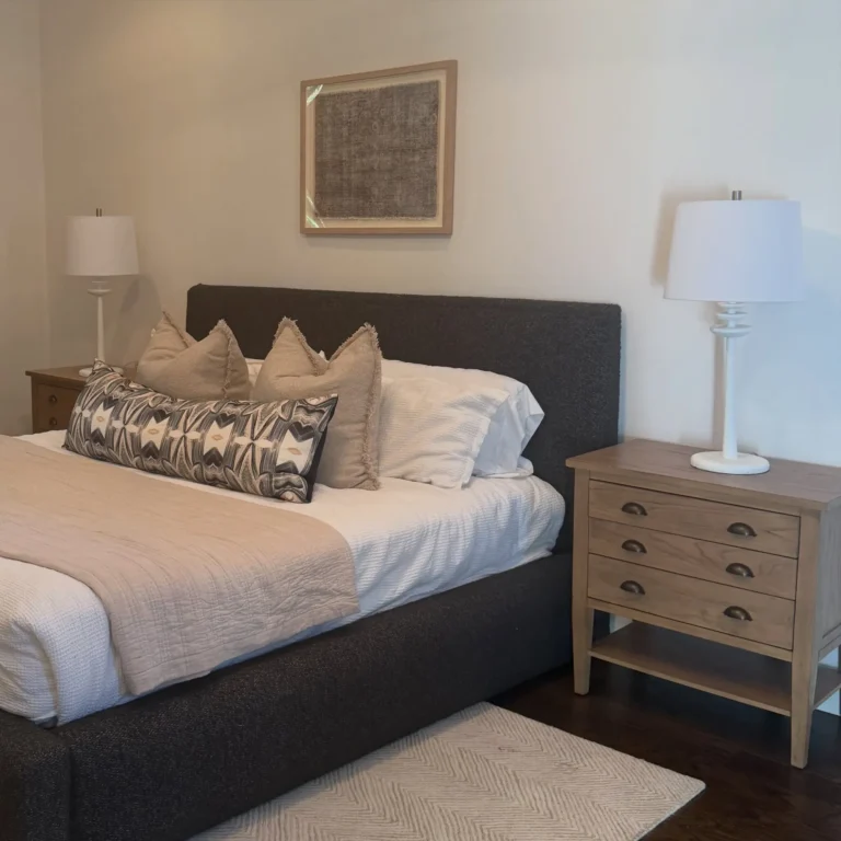 Staged bedroom with an upholstered bed, layered pillows and nightstand lamps – home staging Oklahoma City by Live Boho