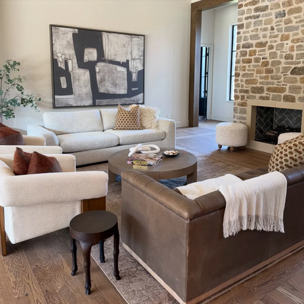 Staged living room with two different sofas, a stone fireplace and abstract art – home staging Oklahoma City by Live Boho